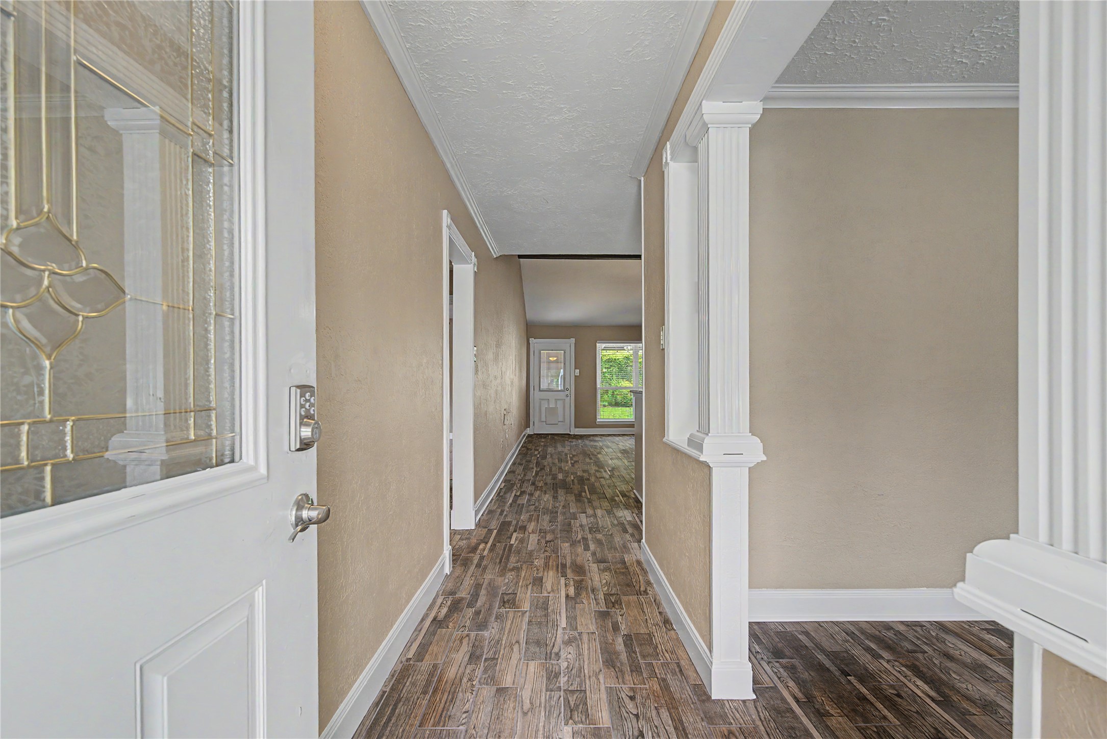 4210 Mossygate Drive Spring, TX 77373 - Photo 5 of 33 The photo shows a welcoming entryway with wood-look tile flooring and neutral walls.