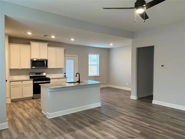 a kitchen with stainless steel appliances granite countertop a sink stove and refrigerator