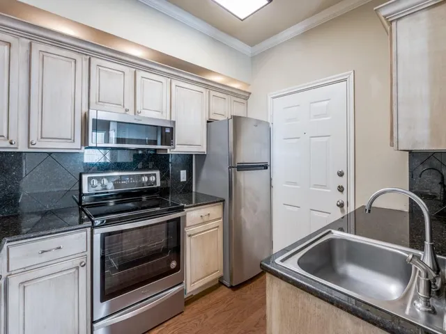 a kitchen with white cabinets and stainless steel appliances