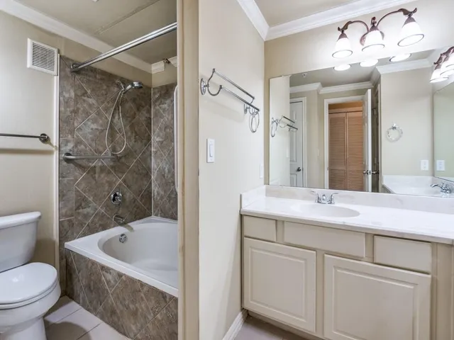 a bathroom with a granite countertop sink a toilet and shower