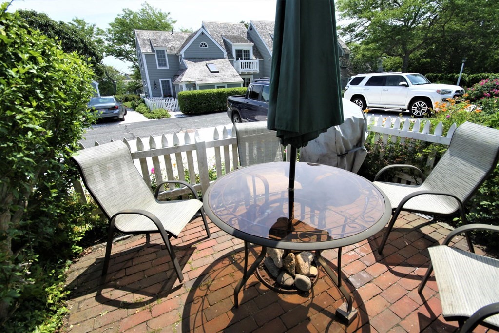 16 Brant Rock Road Mashpee, MA 02649 - Photo 16 of 22 a view of a patio with table and chairs and potted plants