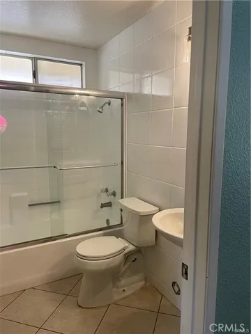 a white toilet sitting next to a bathroom sink and a shower
