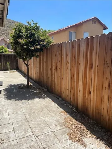 a view of a backyard with wooden fence
