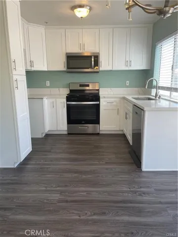 a kitchen with a sink a microwave and cabinets