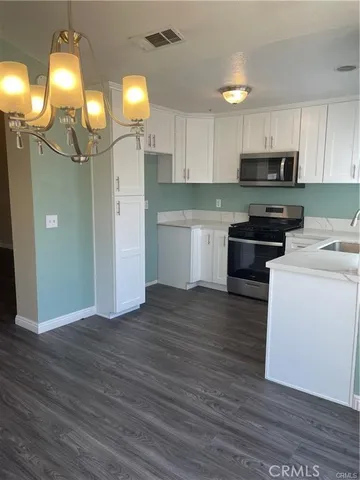 a kitchen with cabinets and wooden floor