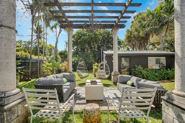 a view of a patio with couches table and chairs and potted plants