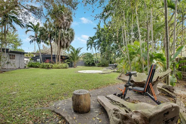 a front view of a house with a yard and palm trees