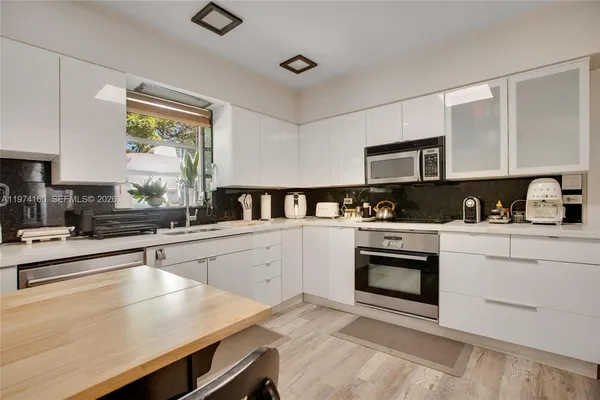 a kitchen with granite countertop a stove a sink and a microwave
