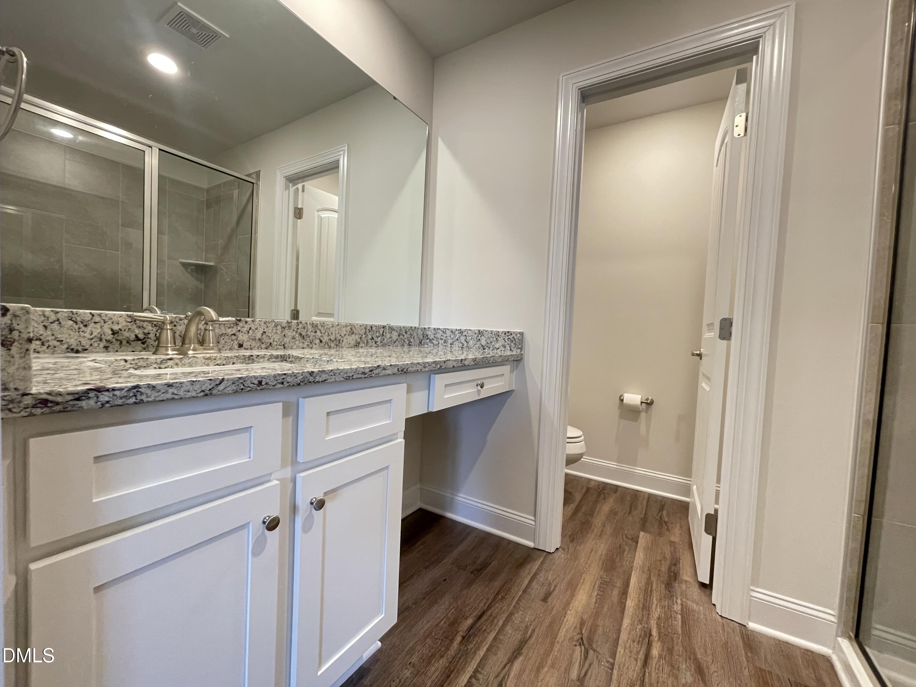 6911 Outfall Point Lane Raleigh, NC 27616 - Photo 33 of 34 a bathroom with a granite countertop sink toilet and mirror