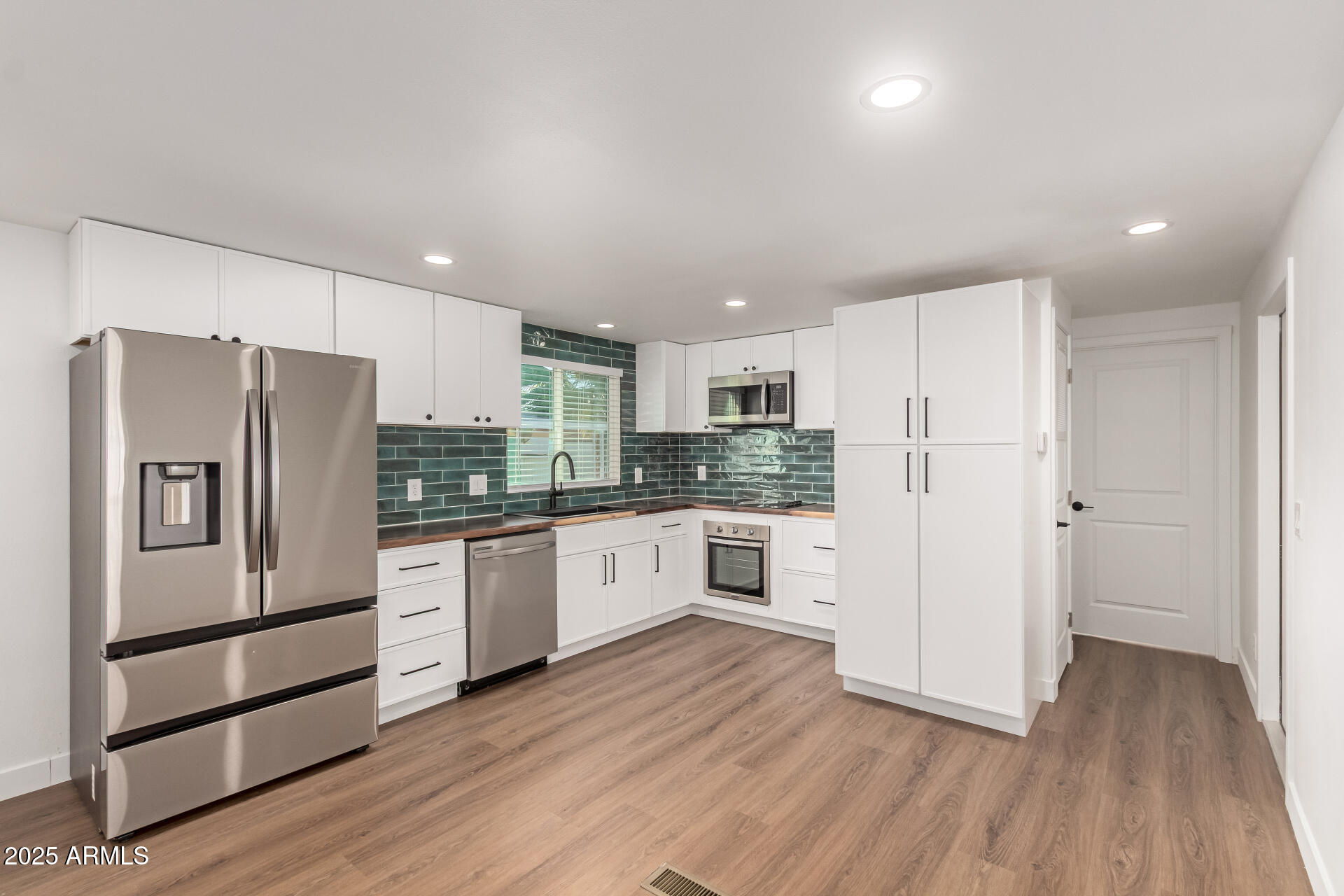 a kitchen with stainless steel appliances a refrigerator and wooden cabinets