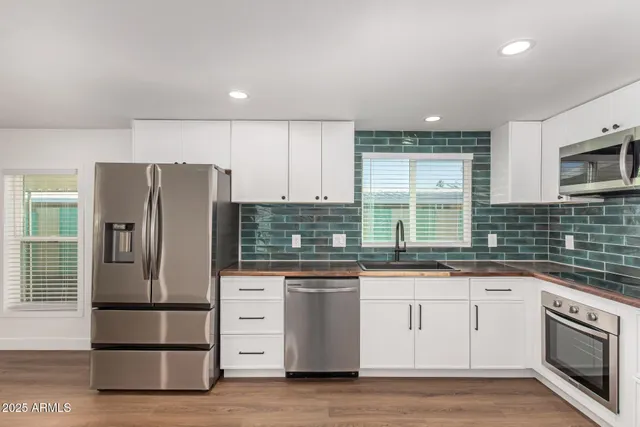 a kitchen with stainless steel appliances granite countertop a refrigerator and a stove top oven
