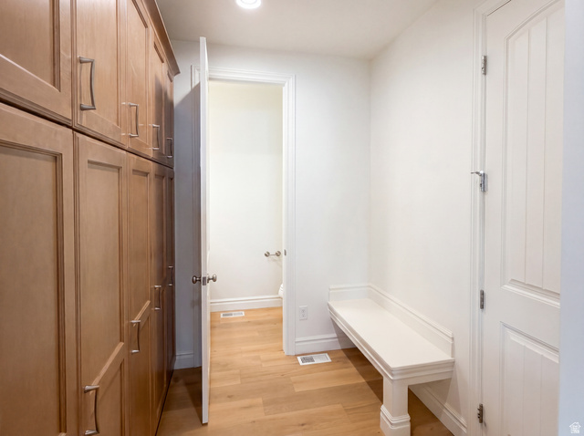 1251 North 2525 West Clinton, UT 84015 - Photo 25 of 30 Custom wood cabinetry with brushed nickel hardware, wood-finish flooring, recessed lighting, and a built-in white bench