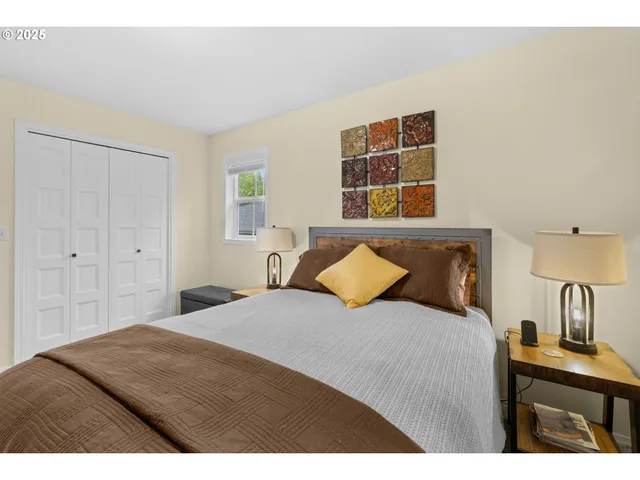 a bedroom with a bed and painting on the wall