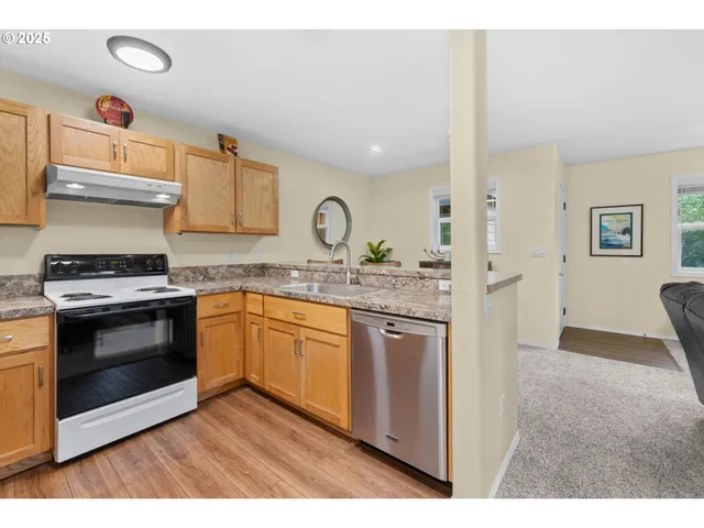a kitchen with granite countertop a sink stove and cabinets
