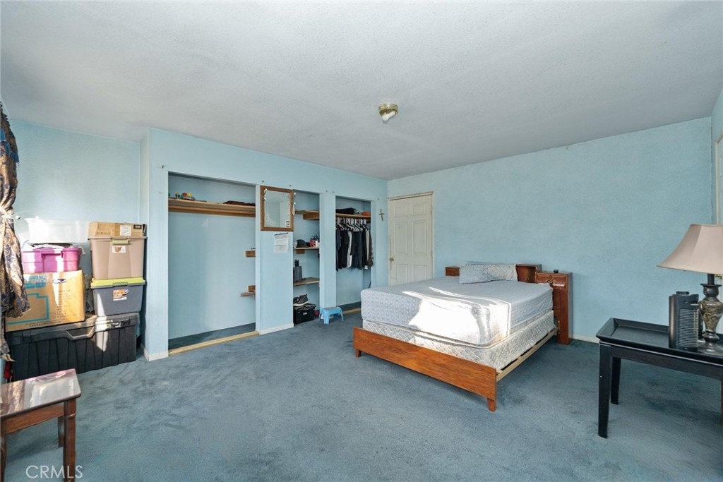 8925 Penny Drive Riverside, CA 92503 - Photo 33 of 48 a spacious bedroom with a bed and a table in it