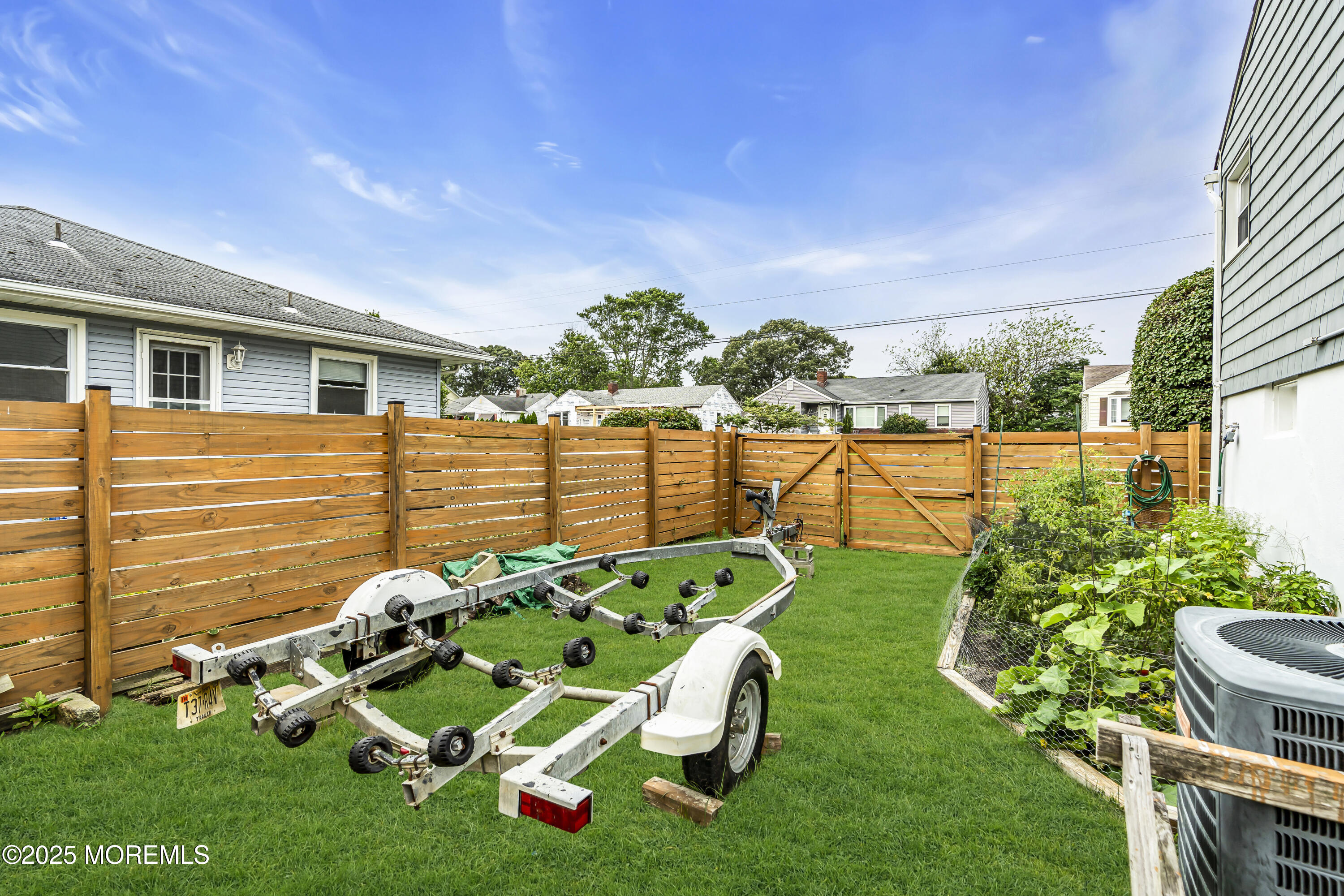1400 Treeneedle Road Point Pleasant, NJ 08742 - Photo 45 of 45 a backyard of a house with table and chairs plants and large tree