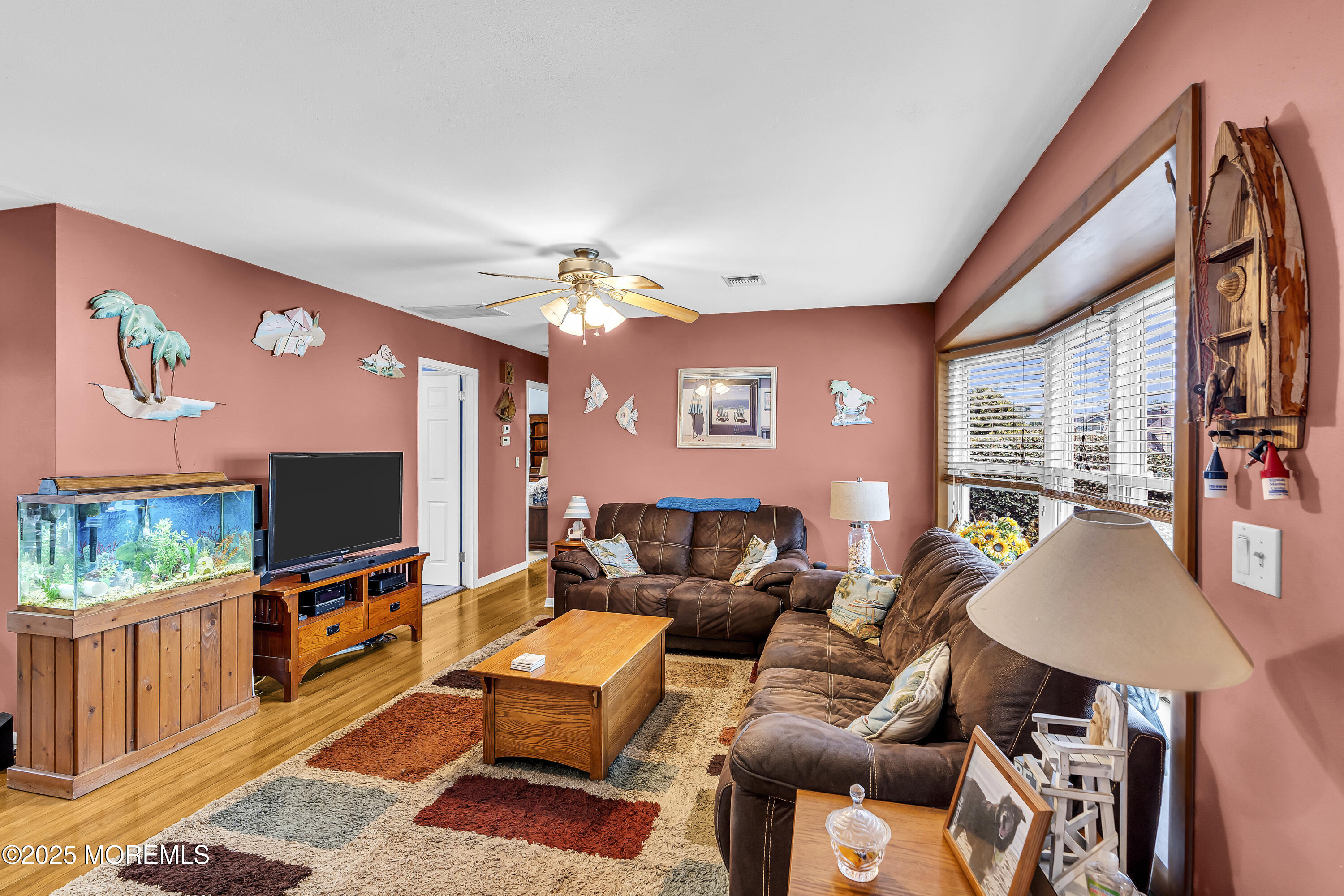 1400 Treeneedle Road Point Pleasant, NJ 08742 - Photo 9 of 45 a living room with furniture a flat screen tv and a floor to ceiling window