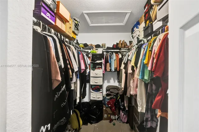 a view of walk in closet with clothes and shoes