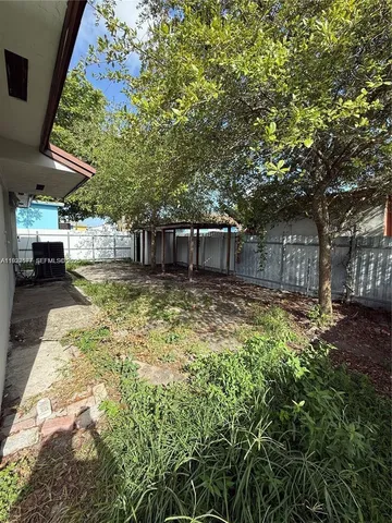 a view of a house with a large tree and a yard