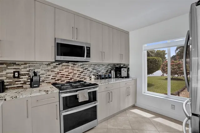 a kitchen with granite countertop white cabinets stainless steel appliances and a sink