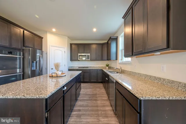 a kitchen with granite countertop stainless steel appliances and wooden cabinets