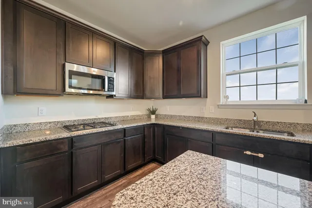 a kitchen with stainless steel appliances granite countertop a sink stove and microwave