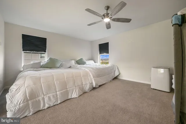 a bedroom with a large bed and a ceiling fan