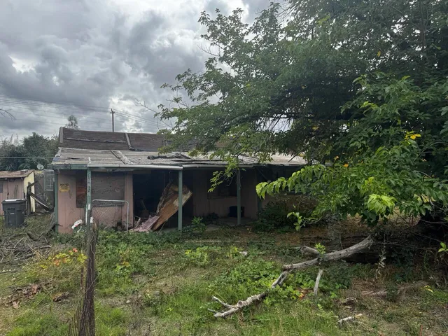 a view of a house with a backyard and a tree