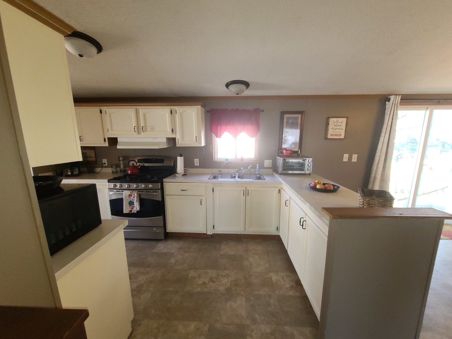 291 Highway 2, Unit 49 Dixon, IL 61021 - Photo 14 of 28 a kitchen with stainless steel appliances a sink a stove a refrigerator cabinets and a window