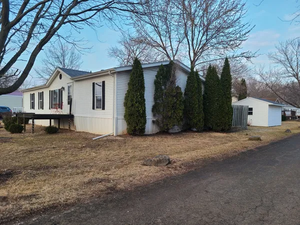 a view of a house with a yard and large tree