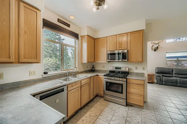 a kitchen with stainless steel appliances granite countertop a stove a sink and a microwave