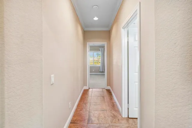 a view of a hallway with wooden floor and a bathroom
