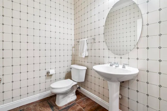 a bathroom with a toilet sink and mirror