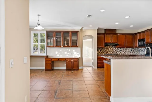 a kitchen with granite countertop a stove and a refrigerator