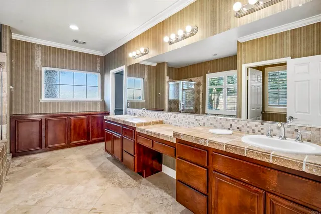 a spacious bathroom with a granite countertop double vanity and a large mirror