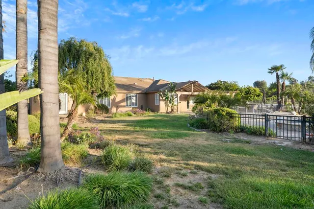 a view of a house with a big yard and large trees