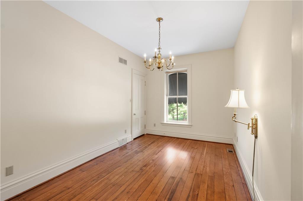 571 West McMurray Road Canonsburg, PA 15317 - Photo 24 of 47 Well-appointed bedroom featuring rich pine floors, an ornate chandelier, and a deep-set window overlooking the 14-acre property. Neutral paint and classic details maintain the home’s historic feel