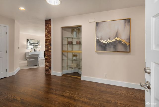 an empty room with wooden floor and a bathroom