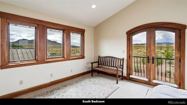 a bedroom with a bed and large windows