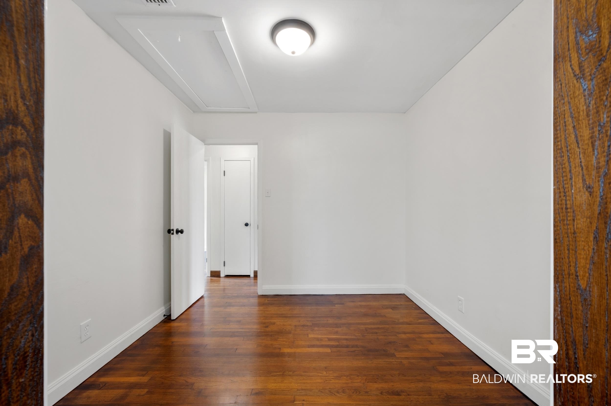 35780 Spring Road North Stapleton, AL 36578 - Photo 13 of 41 Spare room with dark wood-style floors and attic access