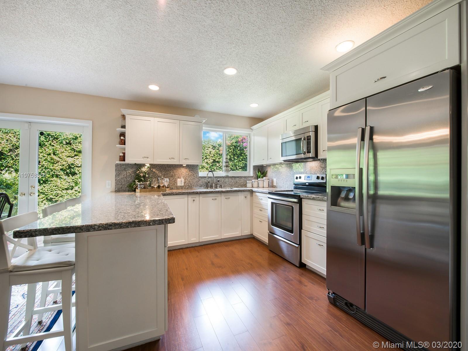 6701 Southwest 49th Terrace Miami, FL 33155 - Photo 8 of 24 a kitchen with kitchen island granite countertop stainless steel appliances a sink and a window
