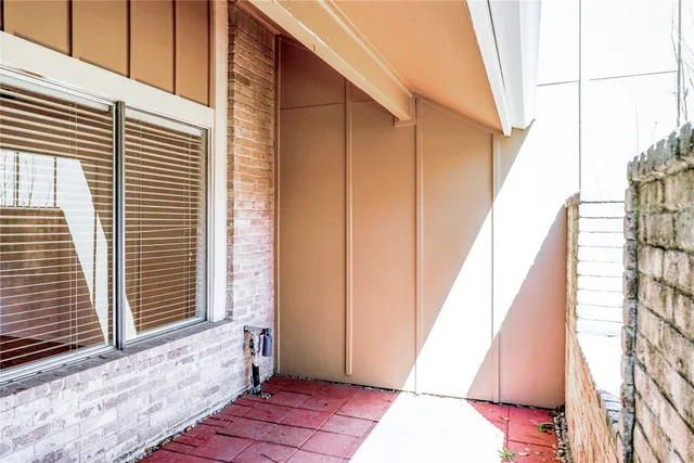 a view of an empty room with wooden floor fireplace and a window