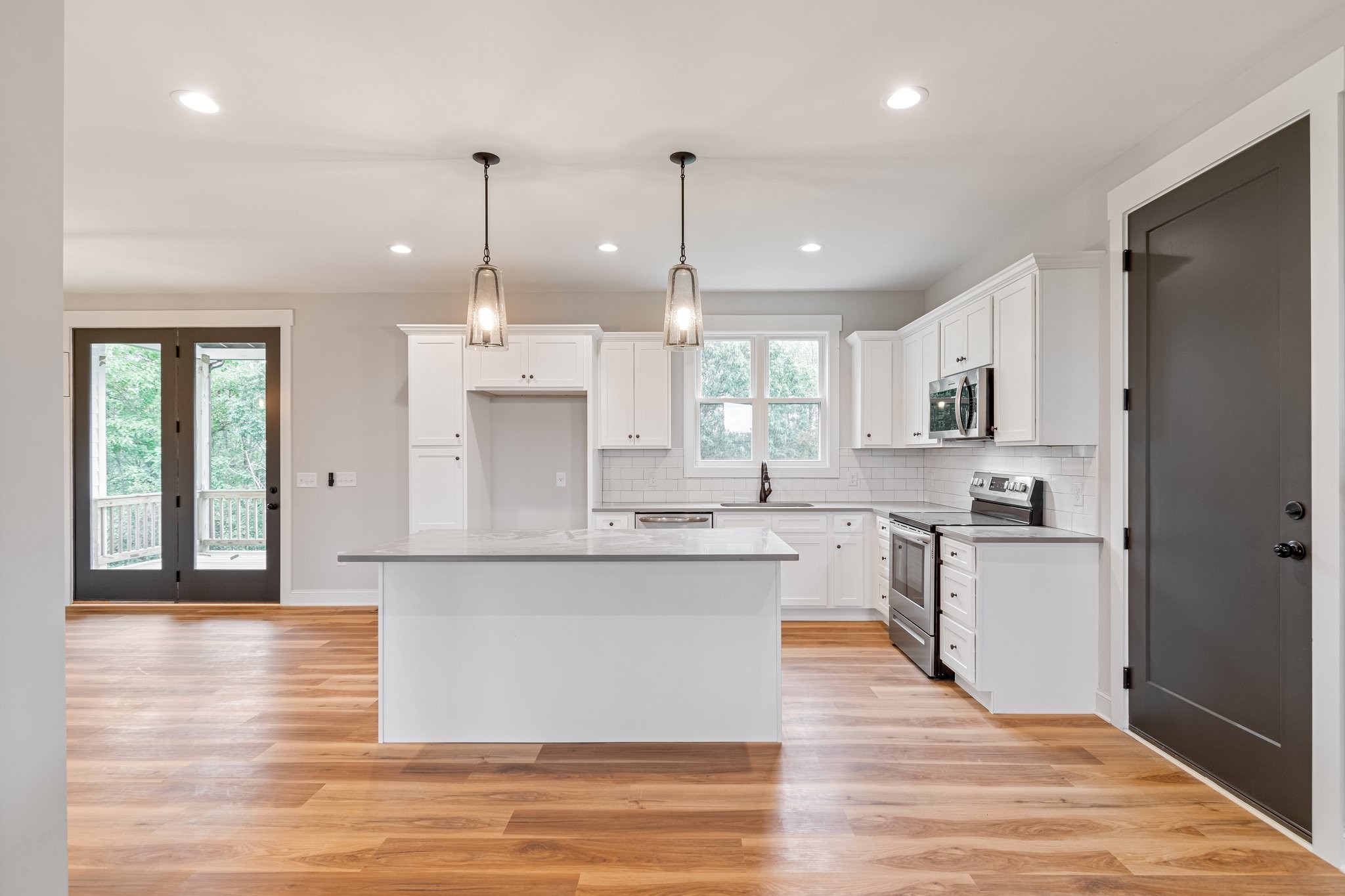 2675 Monte Murrey Road Lewisburg, TN 37091 - Photo 14 of 61 a large kitchen with stainless steel appliances kitchen island granite countertop a stove a sink a refrigerator and white cabinets with wooden floor