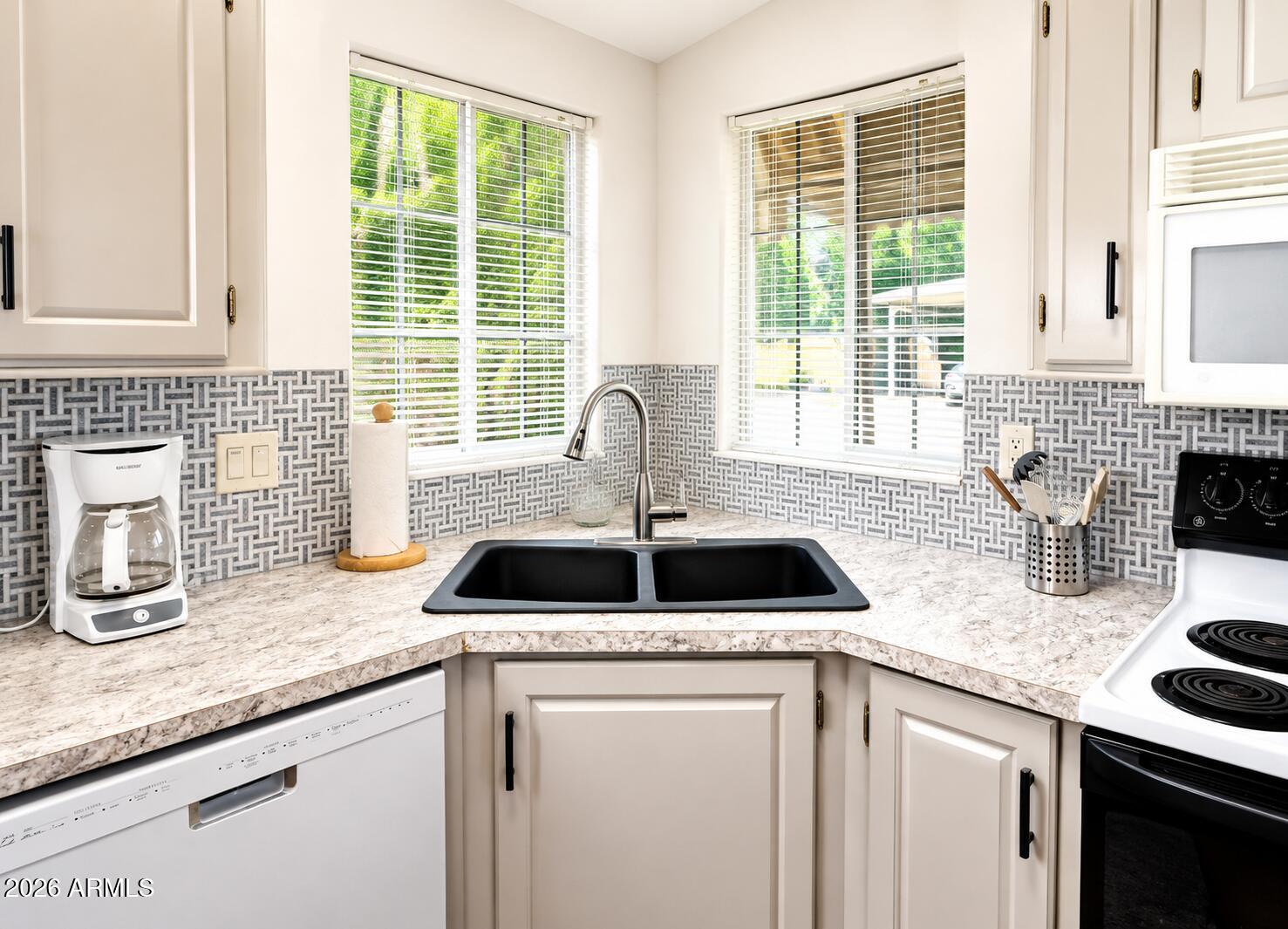 8865 East Baseline Road, Unit 103 Mesa, AZ 85209 - Photo 12 of 47 a kitchen with granite countertop a sink and a window
