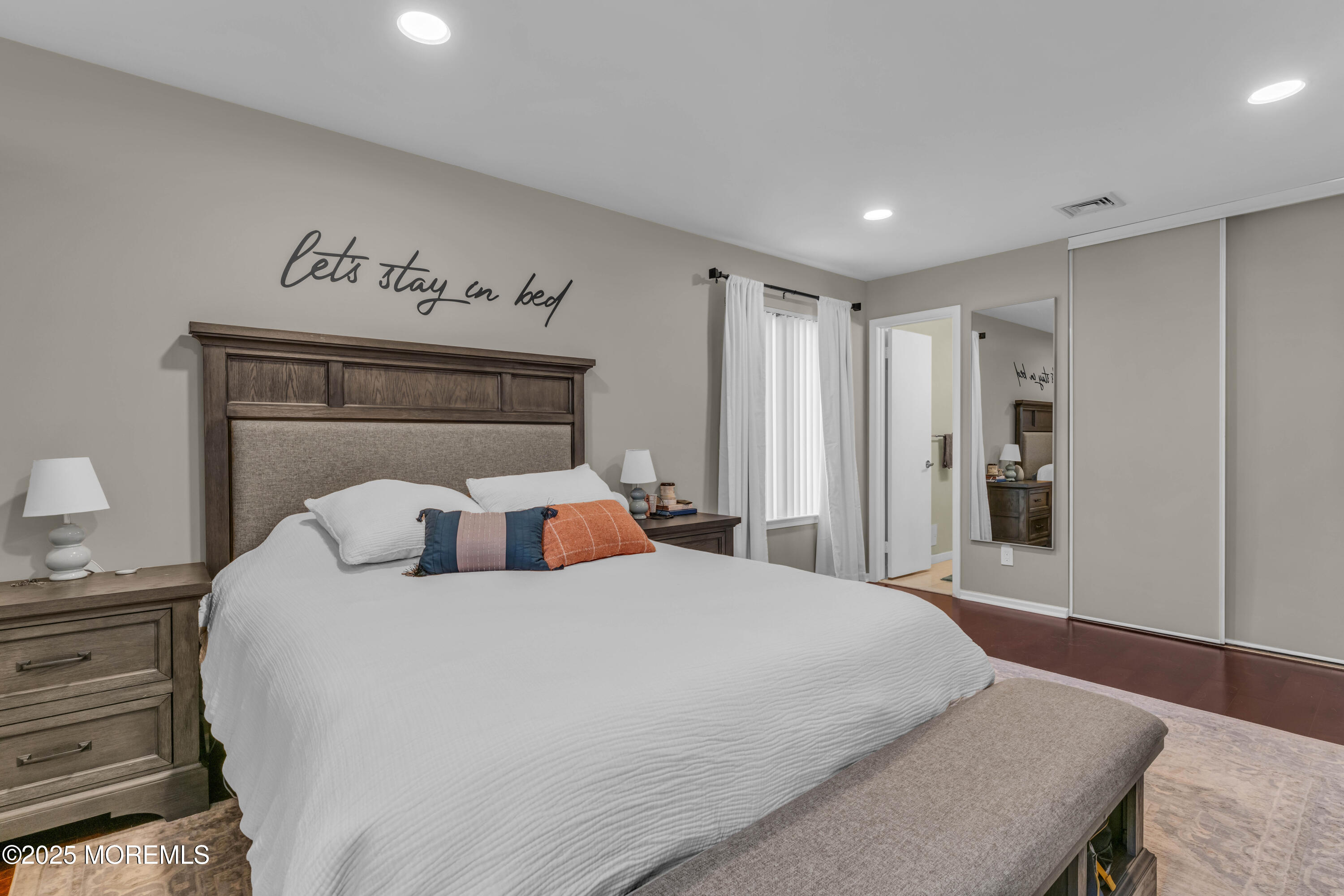 38 Kiwi Loop Howell, NJ 07731 - Photo 24 of 32 a bedroom with a large bed and a chandelier