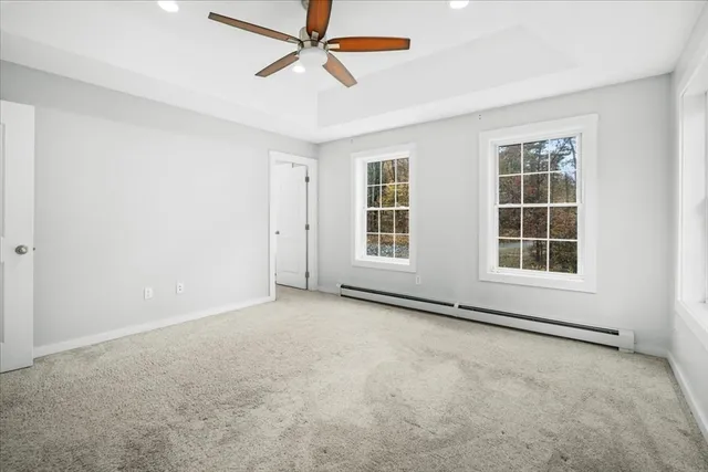 an empty room with windows and fan