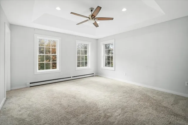an empty room with windows and ceiling fan
