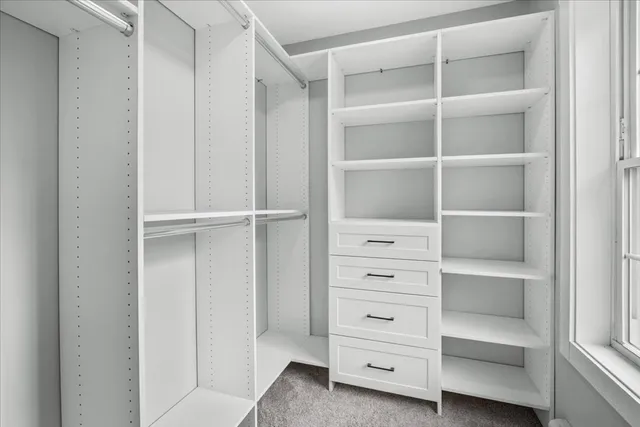 a view of walk in closet with empty racks