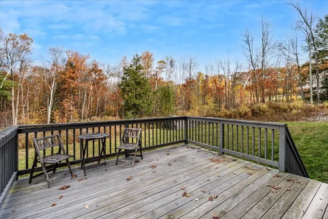 a view of deck with wooden floor and trees with wooden fence