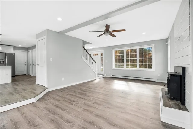 a view of empty room with wooden floor and fireplace